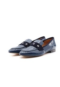 Navy patent leather loafers with a suede strap, featuring two eyelet accents and a low heel. Smooth texture and pointed toe design.