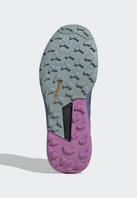 Suela de zapato de goma gris con una sección morada, que presenta un patrón de textura en la tracción. Acabada con un área negra y la marca Continental.