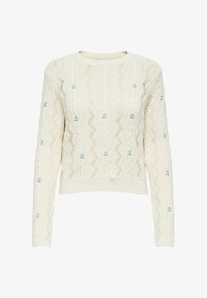 Pull en tricot crème avec un motif en zigzag texturé et des détails de broderie florale bleue. Dispose d'un col rond et de manches longues.