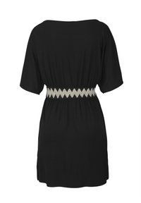 Black short-sleeve dress with boat neckline and elastic waistband featuring a white zigzag pattern, shown from the back.