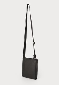 Borsa a tracolla nera di forma rettangolare, realizzata in materiale sintetico liscio, con tracolla regolabile e design minimalista.