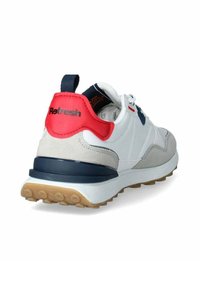 Zapatilla blanca con acentos de ante gris y panel trasero rojo. Presenta una suela ligera, detalles en azul marino y una suela de goma texturizada para mayor agarre.