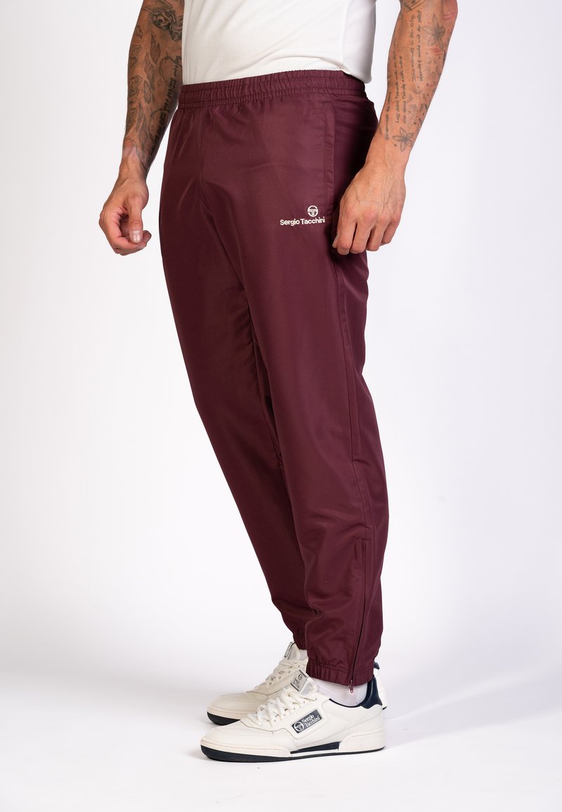 Bordeauxfarbene Jogginghose aus leichtem Stoff, mit elastischem Bund und Seitentaschen. Logo auf dem linken Oberschenkel bedruckt.