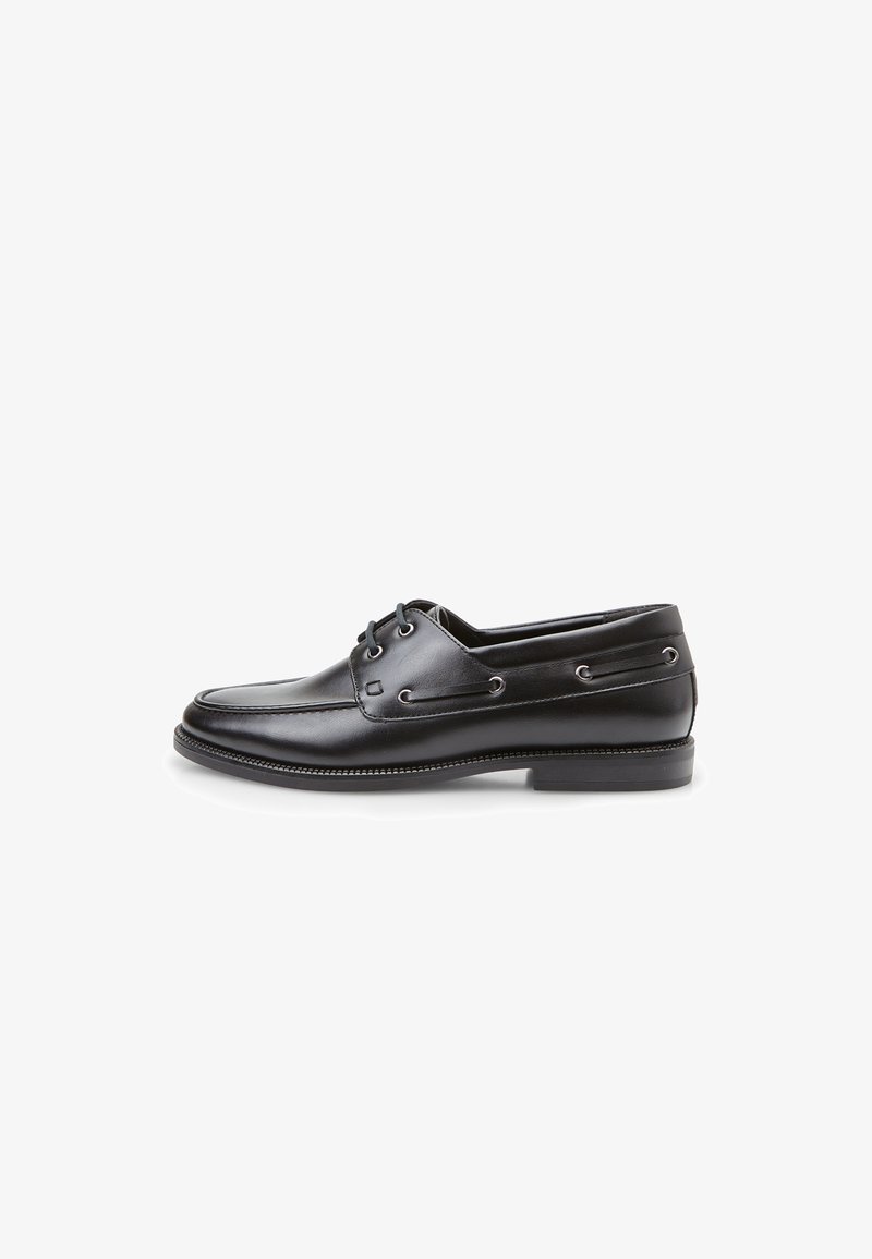 Zapato náutico de cuero negro con punta redonda, cordones a través de ojales metálicos y perfil bajo. Cuenta con suela texturizada y costuras mínimas.