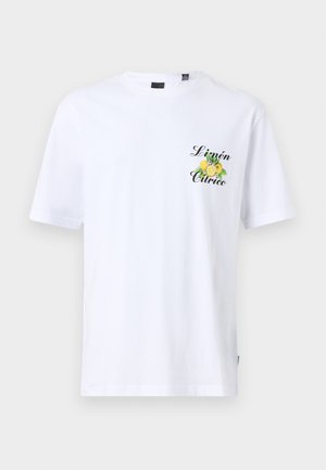 Λευκό βαμβακερό μπλουζάκι με κοντά μανίκια, με γραφικό λεμονιού σε πράσινο και κίτρινο, και την ένδειξη "Limón Cítrico" τυπωμένη σε μαύρο στο στήθος.