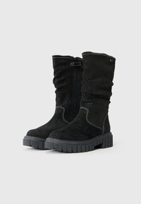 Botas de tornozelo em camurça preta com um design esvoaçante, superfície texturizada, detalhes em prata e uma sola de borracha robusta. Fecho com zíper lateral.