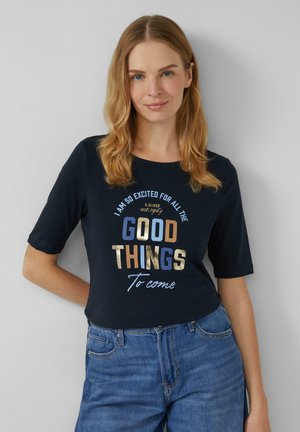 Navyblauwe katoenen T-shirt met korte mouwen, met metallic tekst in goud, blauw en bruin: "IK BEN ZO OPGEWONNEN VOOR ALLE GOEDE DINGEN Die komen."