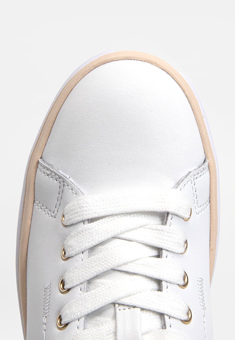 Scarpa sportiva bianca con superficie liscia, punta rotonda e spesse stringhe bianche. Presenta una suola in gomma beige e occhielli dorati per le stringhe.