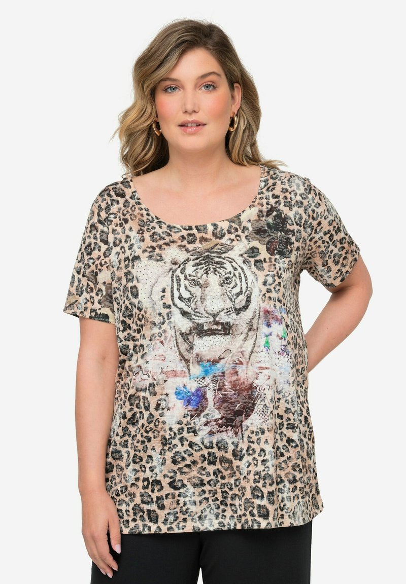 Camiseta de estampado de leopardo con un gráfico central de tigre, mangas cortas, escote redondo, tela suave y corte relajado. Pantalones negros completan el look.