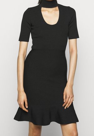 Robe noire côtelée à manches courtes, décolleté plongeant et taille cintrée. Présente un ourlet évasé et des détails texturés sur l'ensemble.