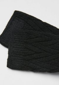Zwarte gebreide hoofdband met een textuur van kabelpatroon. Zacht materiaal met een rekbaar ontwerp voor comfort en warmte.