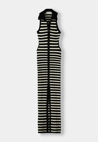 Robe sans manches en ribbed avec un motif rayé noir et blanc, col haut et fermeture à boutons sur le devant, présentant des découpes sur les côtés.
