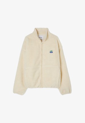 Fleece zip-up jacket in cream with a high collar, two front pockets, and a small blue and green logo patch on the left chest.