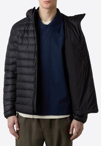 Black puffer jacket with quilted design, featuring a zip closure and attached hood, worn over a navy shirt and light-colored undershirt.