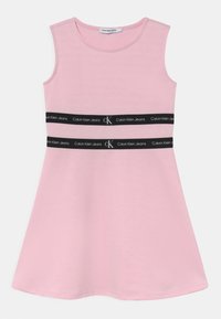 Różowa sukienka bez rękawów, wykonana z miękkiego materiału, o rozkloszowanym kształcie i z dwiema czarnymi taśmami z logo "Calvin Klein Jeans" w okolicy talii.