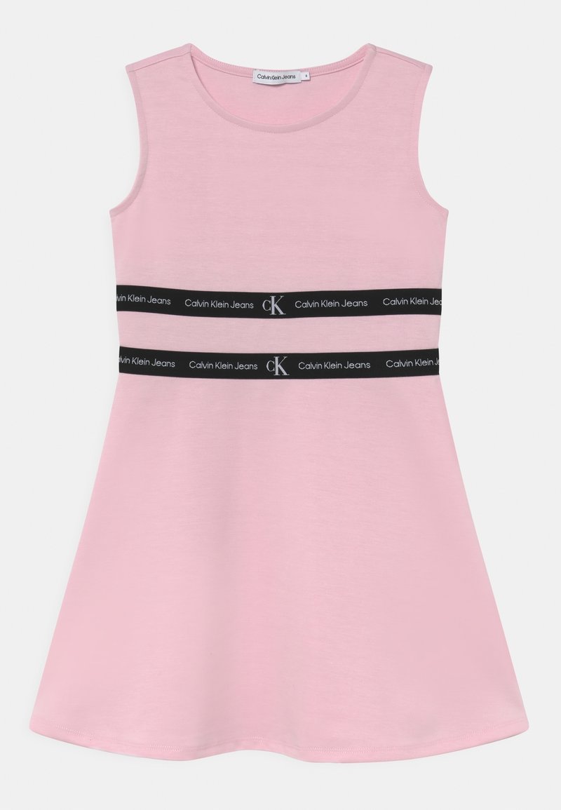 Różowa sukienka bez rękawów, wykonana z miękkiego materiału, o rozkloszowanym kształcie i z dwiema czarnymi taśmami z logo "Calvin Klein Jeans" w okolicy talii.