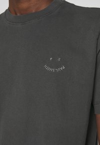 T-shirt en coton gris foncé avec petit logo courbé Paul Smith brodé en fil clair sur la poitrine gauche.