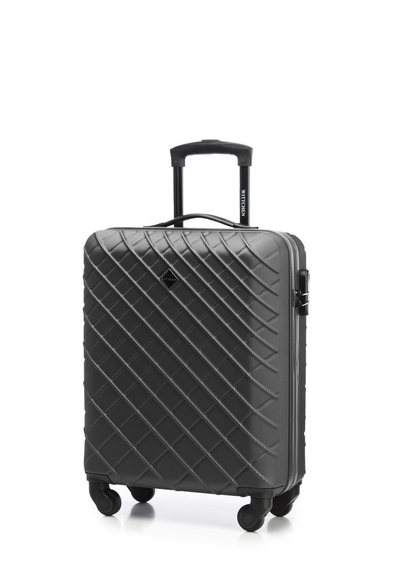 Valise rigide noire avec un motif matelassé, poignée télescopique et quatre roues pour la mobilité. Comprend une poignée latérale et une fermeture éclair.