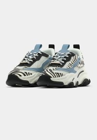 Baskets épaisses avec une tige en mesh blanc, des accents noirs et imprimé zèbre, des éléments bleu clair, et une semelle en caoutchouc texturée noire.