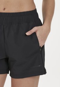 Zwarte sportshorts met een elastische tailleband, zijzak met rits en geborduurd "ENDURANCE" logo op de zoom.
