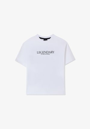 Maglietta bianca in cotone con maniche corte e scollo rotondo. Presenta la scritta "LEGENDARY EVERYWHERE" stampata in nero sul davanti.