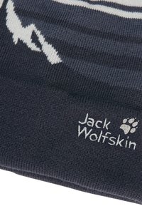 Dunkelblaues Strickmütze mit weißen abstrakten Bergmustern. Verfügt über ein Etikett mit "Jack Wolfskin" und dem weißen gestickten Pfotenabdruck-Logo.