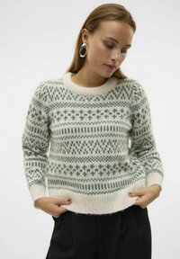 Pull en maille avec un col rond, présentant un motif géométrique vert et crème, une texture douce, et des poignets et un ourlet côtelés.