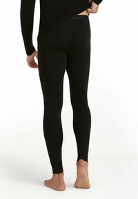 Zwarte leggings van een zacht, rekbaar materiaal, met een strakke pasvorm en platte tailleband, die een gladde textuur vertonen zonder zichtbare patronen.