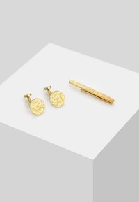 Gold-tone cufflinks with a textured circular design and a matching textured tie bar, all set on a white surface.