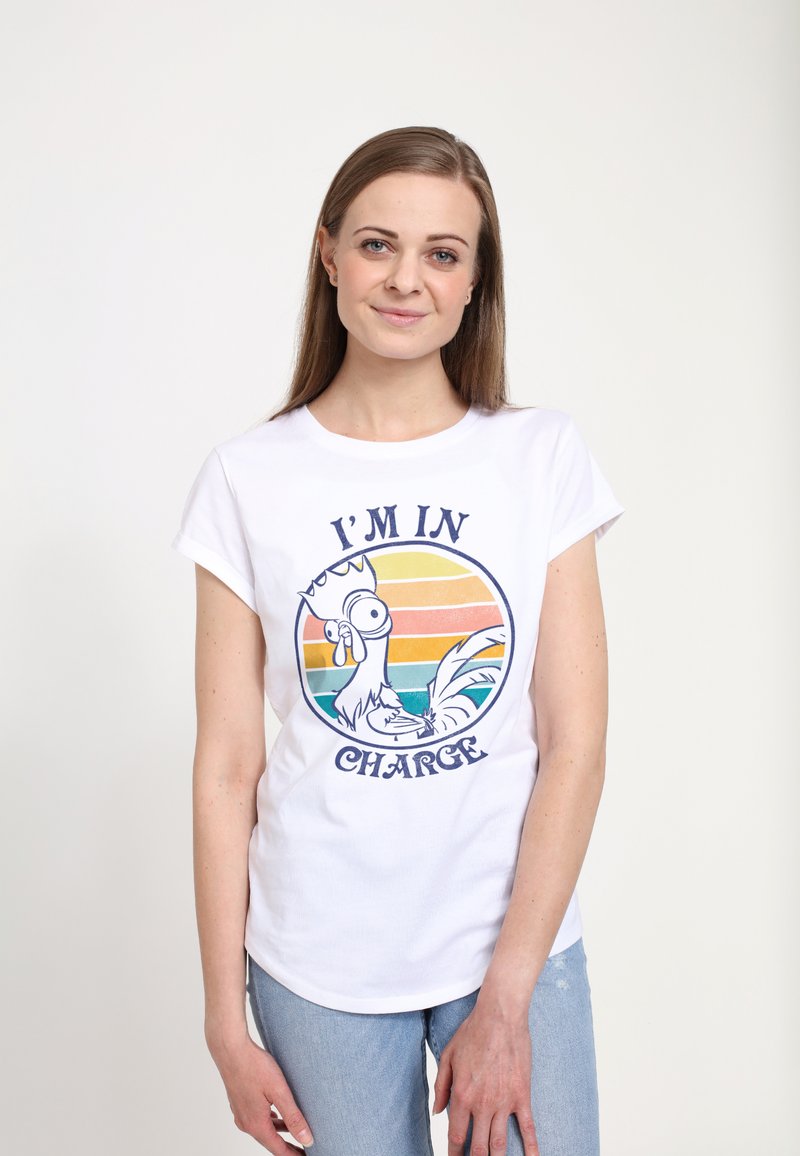 Hvid bomulds t-shirt med en grafik af en tegneseriehaner, der bærer en krone, med teksten "JEG ER ANSVARLIG," sat mod en stribet solnedgangsbaggrund.