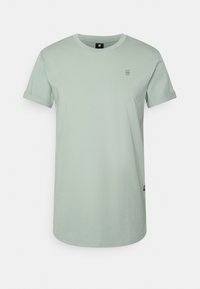 T-shirt en coton vert clair avec des manches roulées, un col rond et un petit logo. Design simple, à coupe droite.