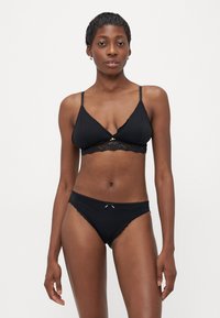 Zwart lingerieset met een driehoekige bralette met kantafwerking en verstelbare bandjes, gecombineerd met bijpassende hooggemaakte slipjes met kantaccenten.