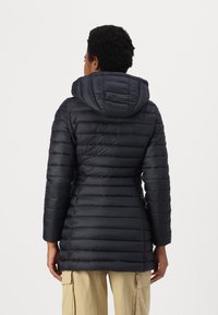 Prošívaná bunda v tmavě modré barvě s kapucí, zdobená prošíváním, kontrastním šitím a přiléhavým střihem.