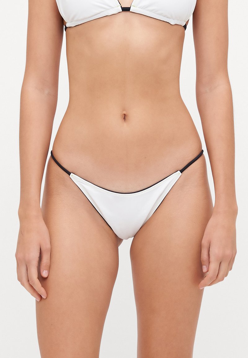Bas de bikini blanc avec des bretelles latérales noires ; présente une coupe triangulaire simple et un matériau lisse. Pas de motifs ni d'ornements supplémentaires.