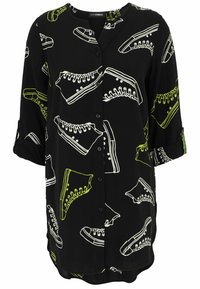 Schwarzes Hemd mit Knöpfen, das weiße und neongrüne Sneaker-Drucke zeigt, mit abgerundetem Saum und hochgerollten Ärmeln. Glatte Stoffoberfläche.