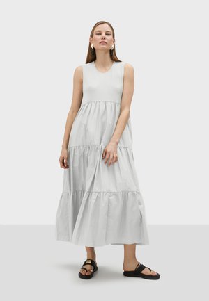 Gray, sleeveless maxi dress with a tiered design, made of lightweight fabric. Features a round neckline and falls to the ankle.