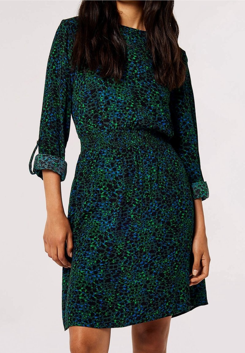 Robe à motifs verts et bleus avec une taille froncée, des manches longues et des poignets retroussés. Fabriquée dans un tissu léger à la texture lisse.