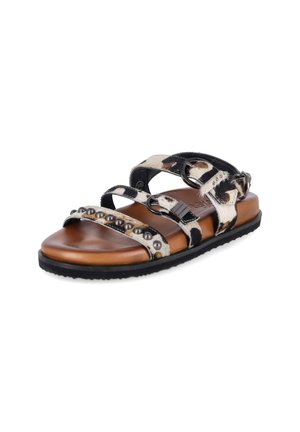Opente sandalen met bruine zool, zwart-witte koeienprint bandjes, metalen studs op het voorste bandje en verstelbare metalen gespen.