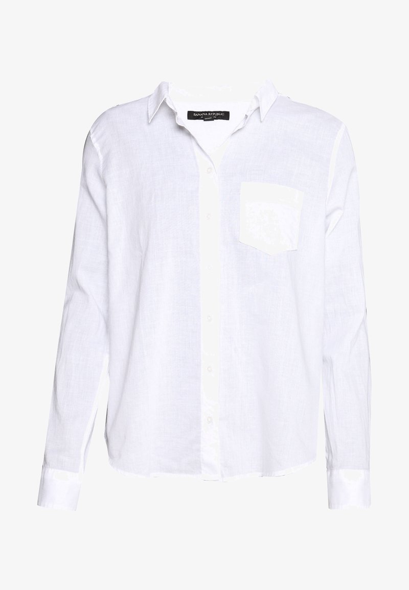 Vit långärmad skjorta i lätt linne. Har knappstängning framtill och en bröstficka. Rena linjer och en avslappnad passform.