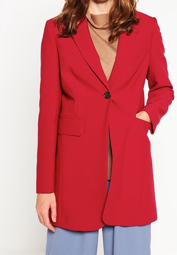 Röd skräddarsydd blazer med notch-lapels, enkel knäppning och framfickor. Bärs över en beige topp och matchas med ljusblå byxor.