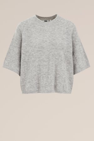 Lichtgrijze gebreide trui met korte mouwen, voorzien van een ronde halslijn en ribbelstructuur. Eenvoudig ontwerp, zachte stof en een ontspannen pasvorm.