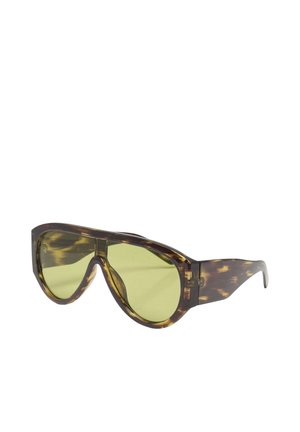 Brune oversized skildpaddemønstrede solbriller med gule tonede linser og tykke stel.