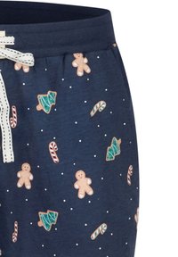 Marineblauwe pyjamashort van katoen met witte trekkoorden; met patroon van peperkoekmannetjes, zuurstokjes en kerstbomen, gestructureerd met kleine stippen.