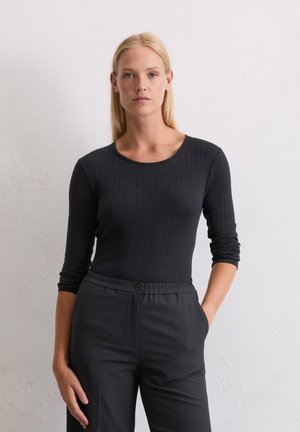 Black ribbed long-sleeve top with a round neckline, paired with black trousers featuring an elastic waistband and button detail.
