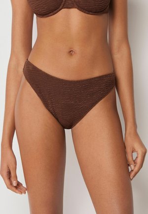 Kvinde iført struktureret brun bikinibund og matchende top, vist fra mave til øvre lår mod en neutral baggrund.