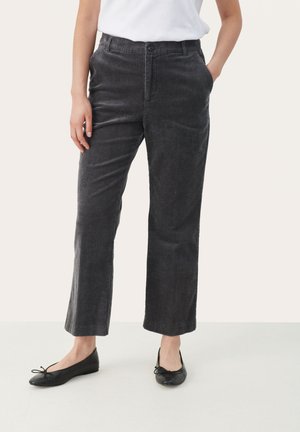 Pantaloni in corduroy grigio con design a gamba dritta, caratterizzati da una chiusura con bottone visibile e tasche, abbinati a scarpe basse nere.