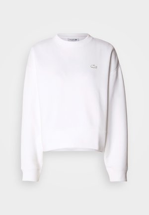 Weißer Cropped-Sweatshirt aus Baumwollmischung, mit Rundhalsausschnitt, langen Ärmeln, gerippten Bündchen und kleinem Lacoste-Logo auf der Brust.