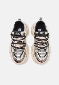 Chunky sneakers met metallic zilveren en beige mesh bovenwerk, zwarte veters en gemusterde accenten. Dikke rubberen zolen voor extra demping.