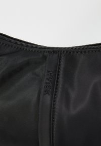 Borsa nera in nylon con una superficie liscia, dotata di chiusura con zip e logo "HYISK" in rilievo sul lato.