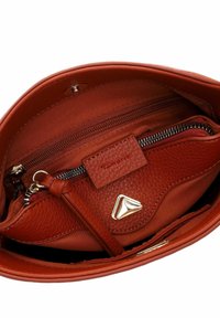 Bolso de mano de cuero rojo con un acabado texturizado, que presenta un bolsillo con cremallera, herrajes dorados y un forro de tela. Diseño compacto con compartimentos organizados.